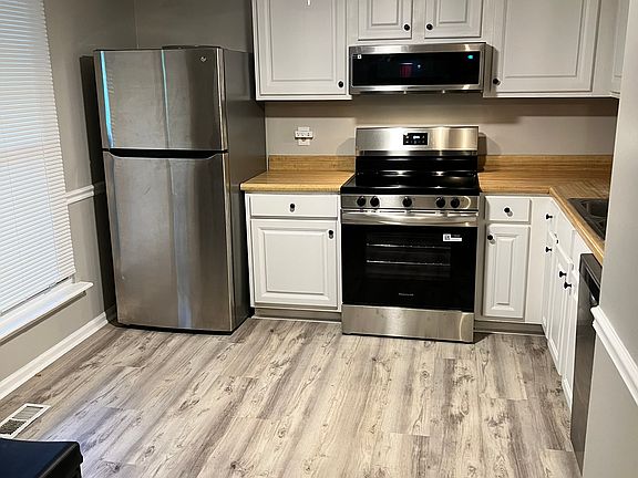 Renovated luxury vinyl kitchen flooring and new cabinets. Stainless steel stove and half-height microwave and dish washer shown