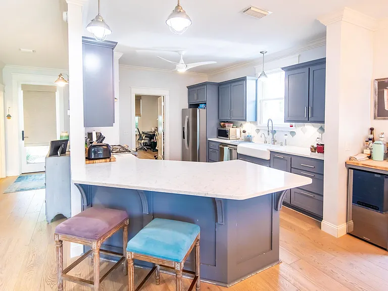 Quartz countertops throughout. Farmhouse sink and a 5-burner gas range/oven. 
Built in bar with a beverage center.