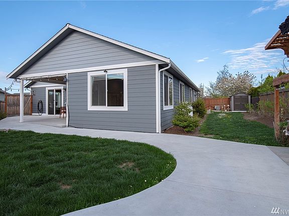 Back yard has swing, garden shed, first class flag pole, heirloom roses, some grassy areas and is gated and fenced.