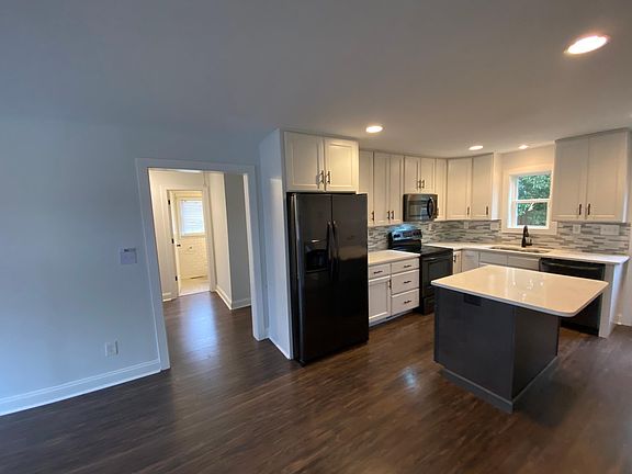 Kitchen to the hallway that connects to a full bathroom, second, and third bedroom.