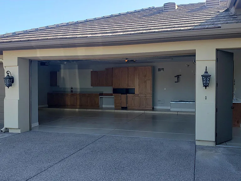 Three car Garage with ample cabinets and counter to the right with sink