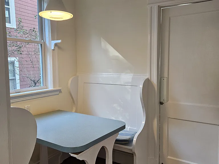 Breakfast nook from kitchen-very sweet built-in with benches and table, swing door to dining room