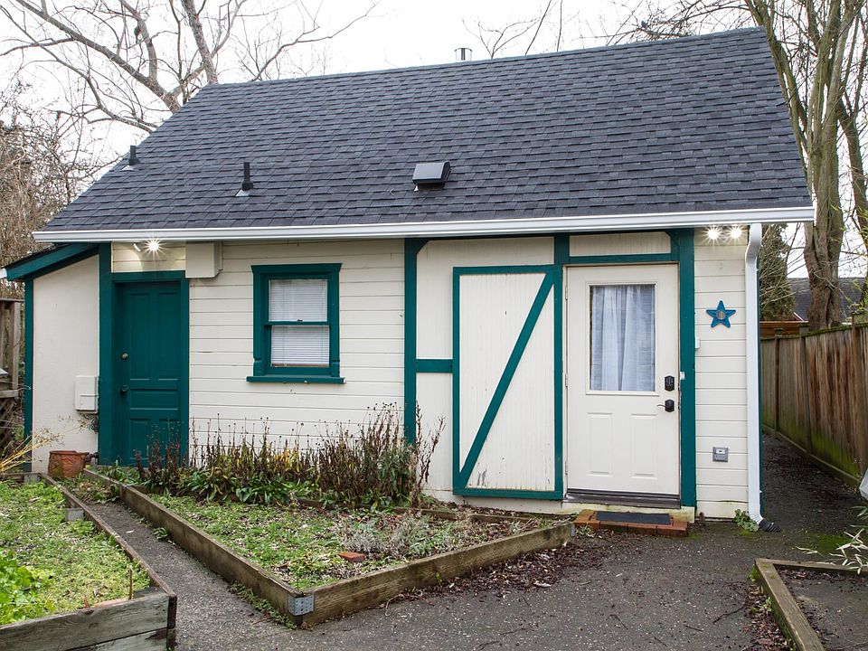 Cottage entry area features raised garden beds and a BBQ gri
