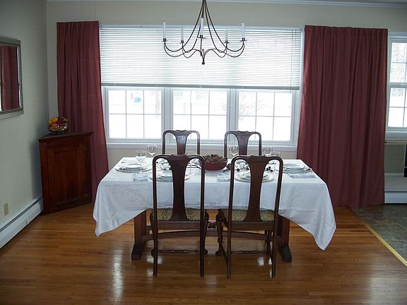The dining room features large windows and beautiful hardwood floors