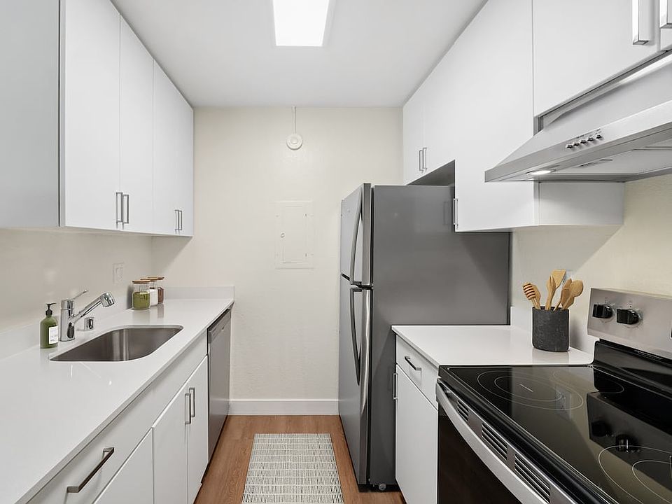 Renovated Package I with white cabinetry, white quartz countertops, stainless steel appliances, and hard surface flooring