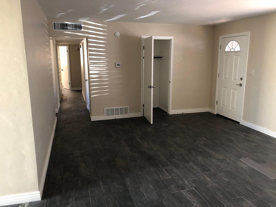 Living room showing front door, closet, and hallway to bedrooms and bathrooms