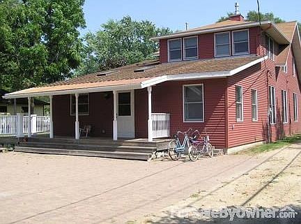 Back of home
						:
						Covered porch, railed deck, parking area between home and garage.