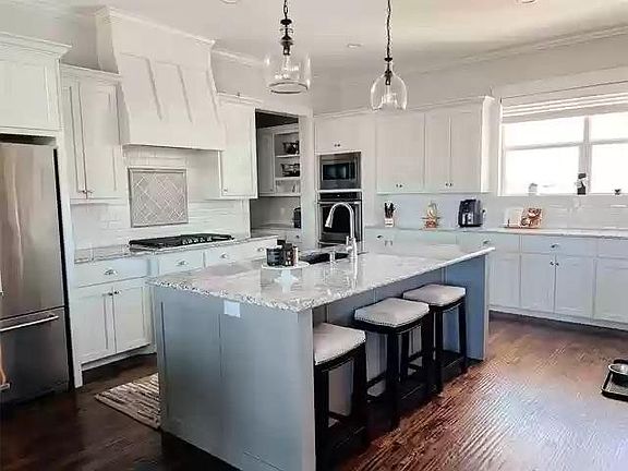 Kitchen boasts tons of cabinet space and large walk-in pantry. 5-burner gas range, double ovens and granite counters