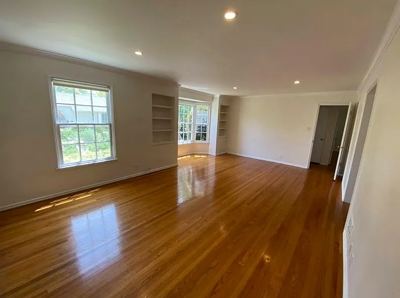 Livingroom with large bay window and built in book shelves.