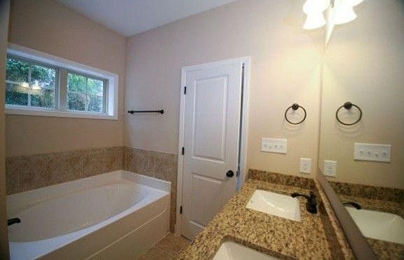 lovely tub, standalone shower, and double vanity in primary bathroom.