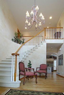 Beautiful foyer with hardwood floors, gorgeous chandelier, & spiral staircase 