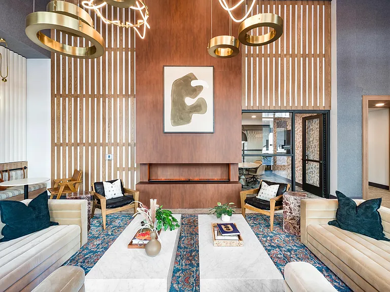 A refined resident lounge at Modera Higley Commons, where warm textures, layered lighting, and thoughtful design create an inviting place to gather.