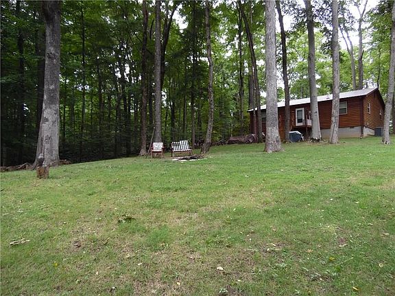 Exterior Back: Gorgeous wooded and level lot! Main-level wood deck with access to the laundry room/m