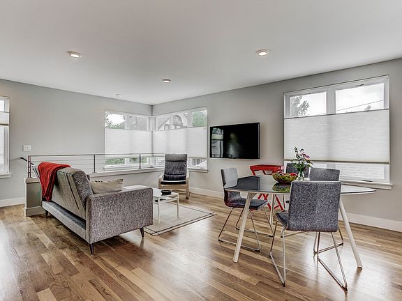 View from the kitchen, showing large wall mounted TV, oak floors