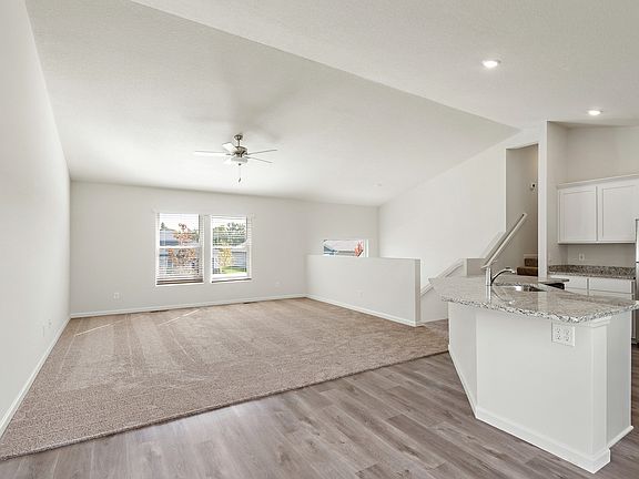 The family room is spacious and has a ceiling fan.