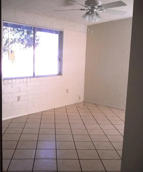 Bright Bedroom with ceiling fan, and all-tile floors