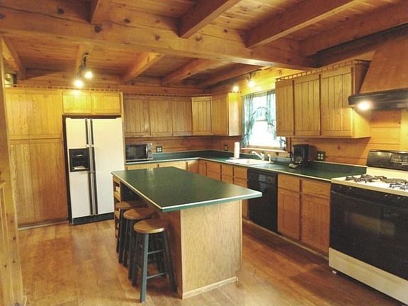 Kitchen measures 16x24 and is a custom kitchen with oak cabinetry, working island and laminate floor