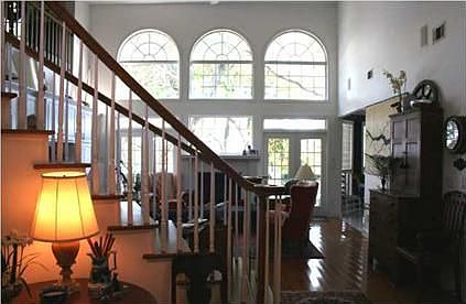 Sunshine beams thru the 2-story window wall