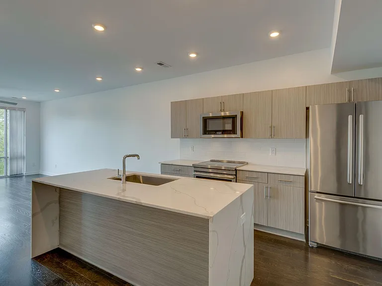 Beautiful Gray Tones, Quartz Countertops and a Waterfall Edge on the Island. Stainless Steel Jenn-Air Appliances including Induction Range.