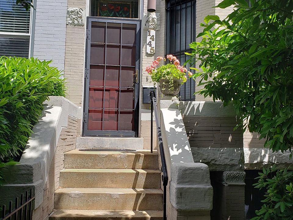Front of house during summer. Basement entrance is down and to the right. Furniture should be moved in through the back entrance, which is wider.