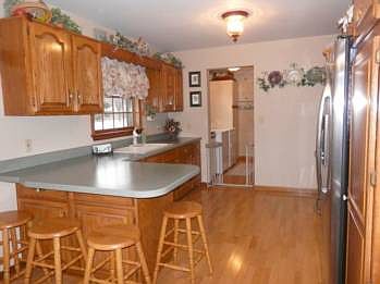 Large newer oak kitchen includes refrigerator, electric range/stove & disposal plus counter space for quick snacks