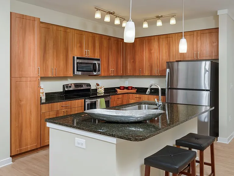 Classic Package I kitchen with stainless steel appliances, oak cabinetry, black granite countertops, and hard surface flooring