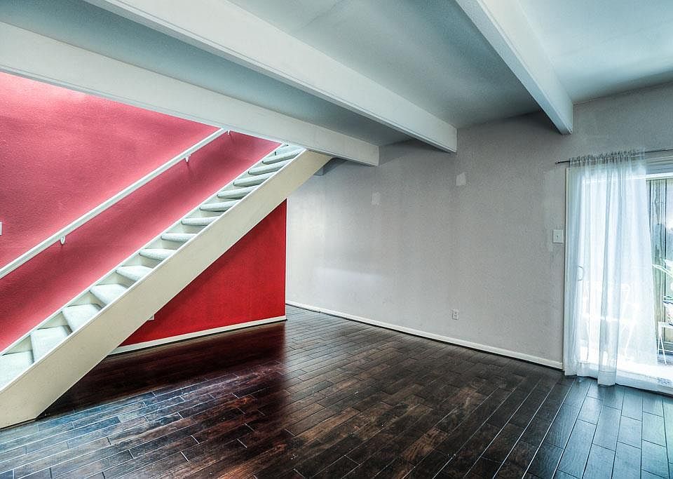 Open staircase into living room with hardwood floors