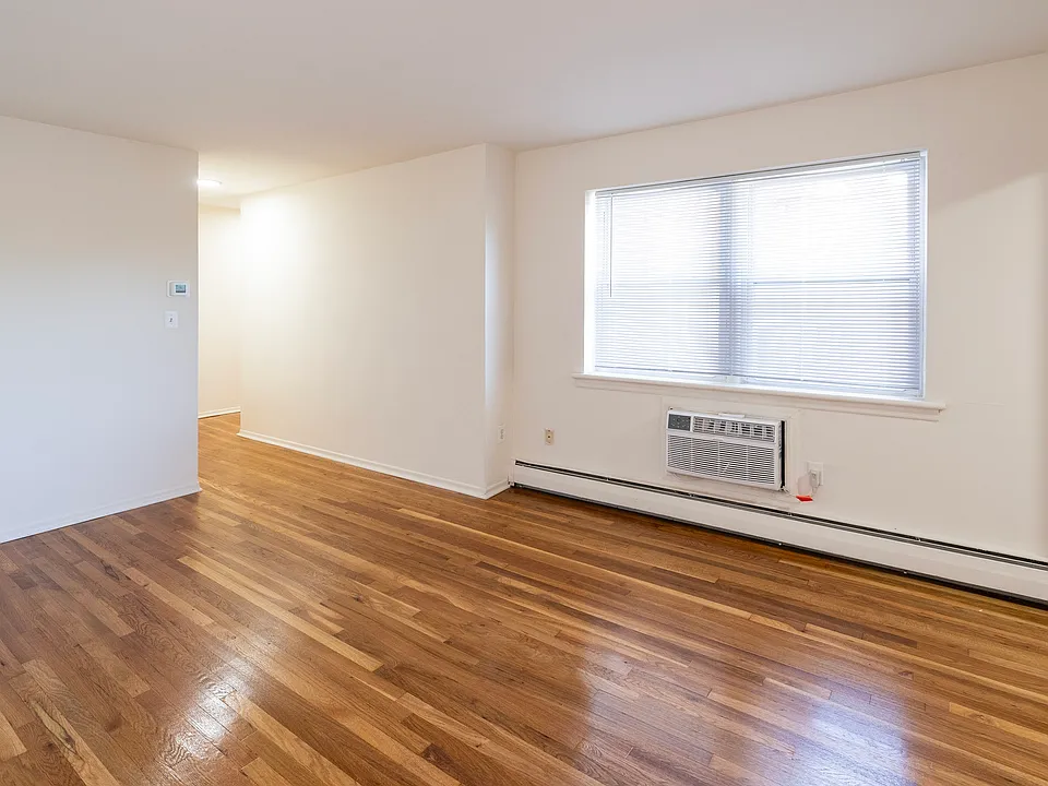 Step into the inviting ambiance of Dorchester House Apartments. This spacious living area boasts beautiful hardwood floors and abundant natural light, perfect for making lasting memories. Schedule your visit today to explore your future home!
