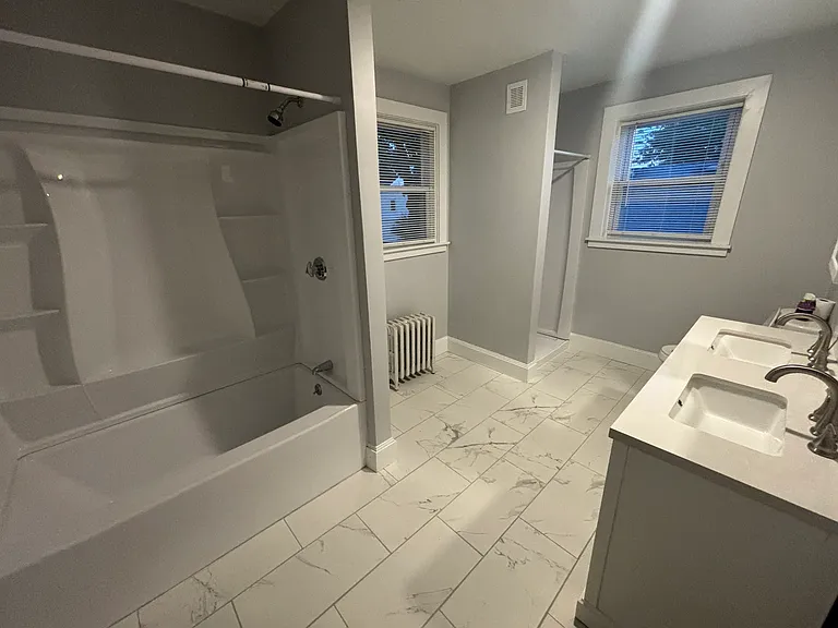 Newly renovated bathroom with a standing shower and bath/shower combo with double vanity.