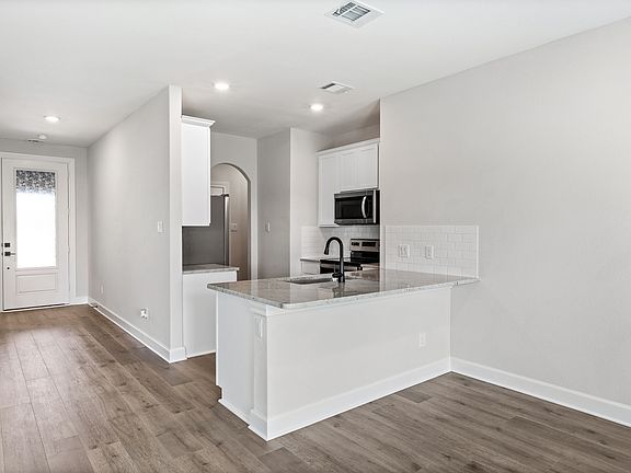 The kitchen has beautiful white cabinetry.