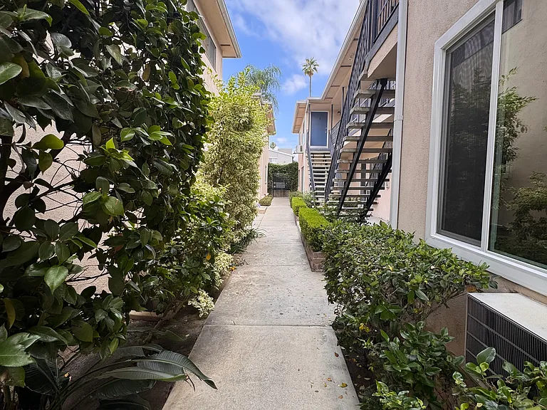 Plants and shrubs create semi private pathways between buildings