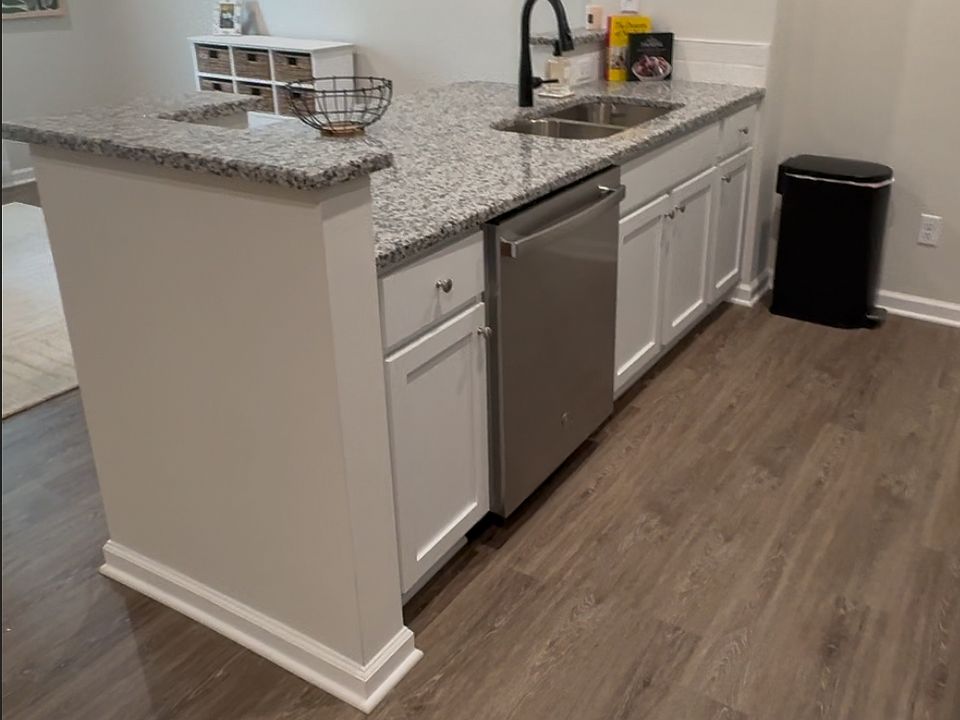 Spacious kitchen with bar seating, stainless steel appliances, and modern finishes.