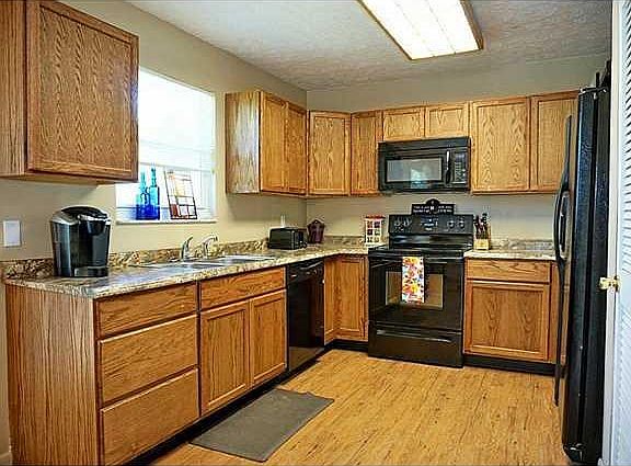 Kitchen. Oak Cabinets, New Counters, & Black Appliances.
