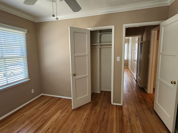 View of Front Bedroom, with closet door open, faux wood blinds on all windows throughout, and ceiling fan