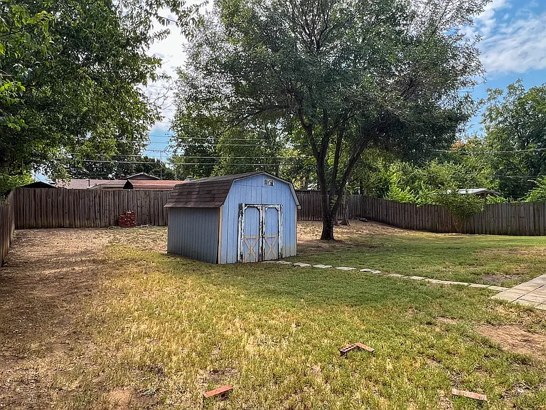 Spacious backyard with mature trees and plenty of open space to enjoy the outdoors.