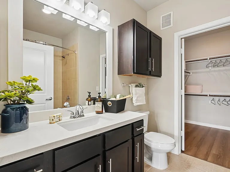 Bath with dark cabinetry, white quartz countertops, and hard surface flooring
