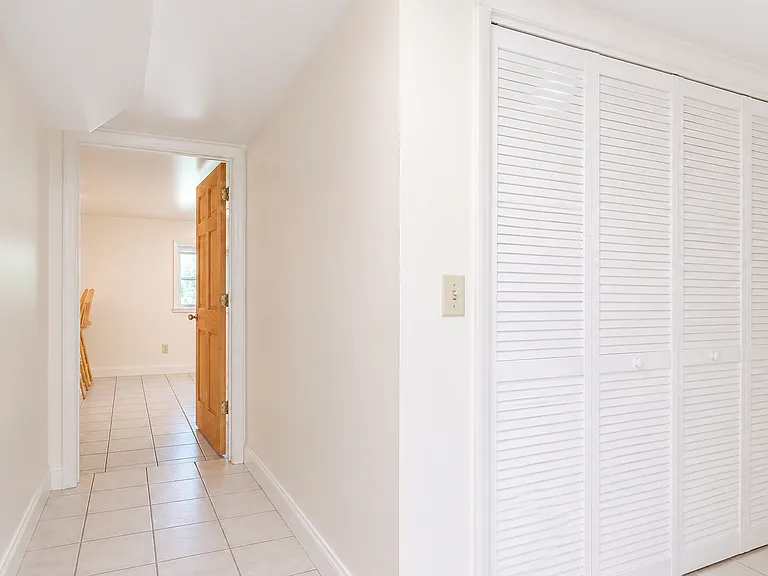 Hallway entryway with closet space for storage and washer/dryer.