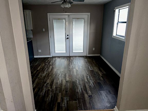 The living room leads into the dining room and kitchen areas. There are French doors that open onto a large backyard deck.