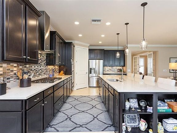 Stunning kitchen with rich 42" wood cabinetry, quartz countertops, soft close drawers, pendant lighting and tile backsplash.