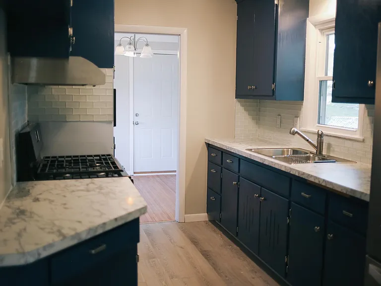 Galley style kitchen with original cabinetry, easy access to living/dining area for daily living or entertaining.