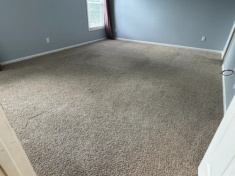 Spacious fourth bedroom with soft carpeting, natural light, and flexible space for guests, office, or additional living.