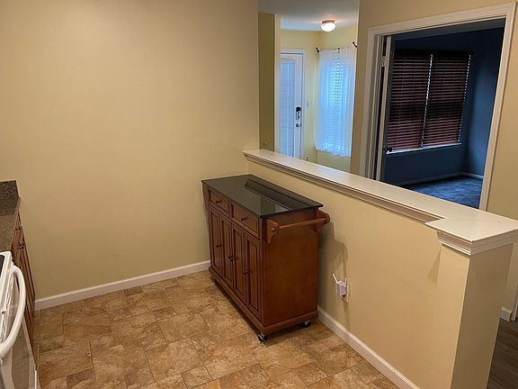 Serving, rolling prep table in the Kitchen with granite top.