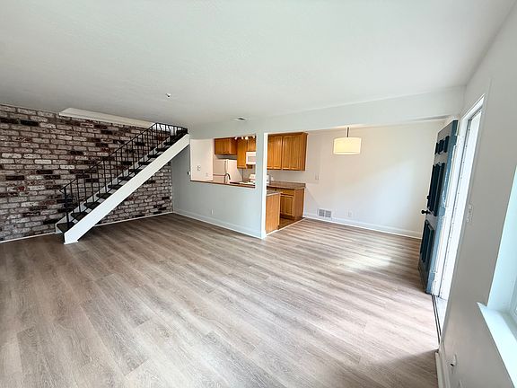 Open floor plan with exposed brick accent wall.