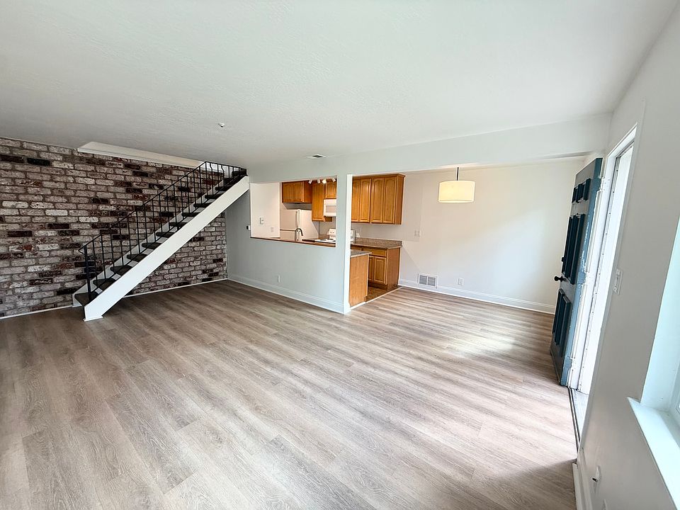 Open floor plan with exposed brick accent wall.