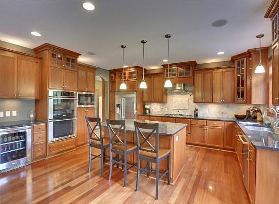 Gorgeous custom cherry cabinets with Brazilian solid wood floors, built-in wine fridge, and double o