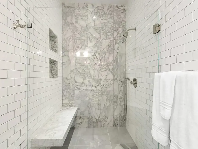 White marble and tile create a perfect backdrop for this rain shower.