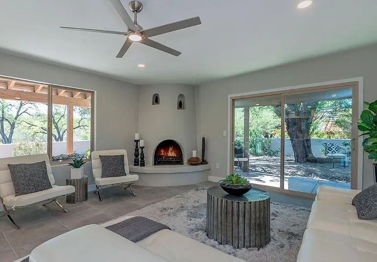 living room with beehive fireplace and 2 sliders to outside patios