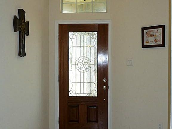 View of front entry from inside features leaded glass door w/ arched transom window & c-tile floor.
