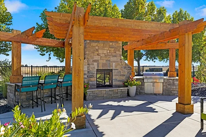 Elegant Outdoor Lounge with Stone Fireplace and Grill
