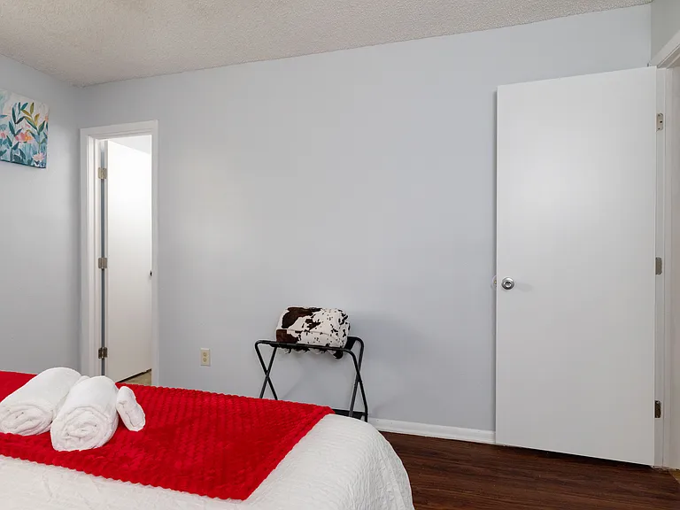 Bedroom 4 offers a spacious layout with a king bed and a convenient luggage rack for guests.